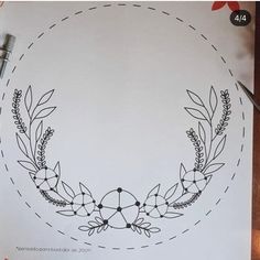 a drawing of a wreath with leaves and arrows on it, next to some scissors