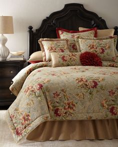 a bed with a floral comforter and pillows