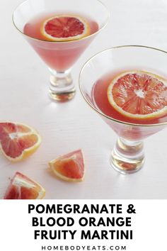 orange pomegranate martini cocktail in coupe glasses with slices of grapefruit