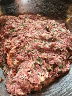 a metal bowl filled with meat and vegetables