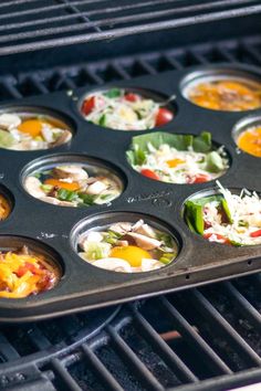 a muffin tin filled with different types of food on top of an open grill