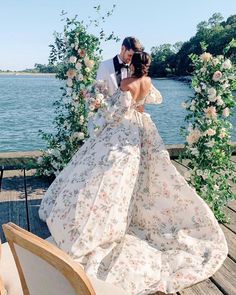 a bride and groom standing on a dock next to the water at their wedding ceremony