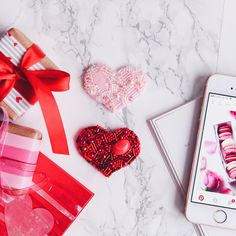 valentine's day gifts and an iphone on a marble table with the phone displaying it