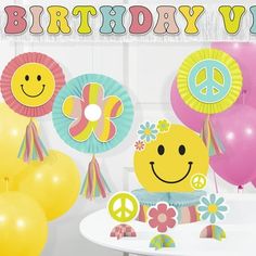 a birthday party with balloons, flowers and peace signs on the table in front of it