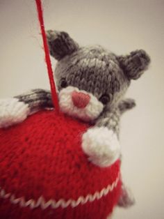 a small stuffed animal hanging from a red ball