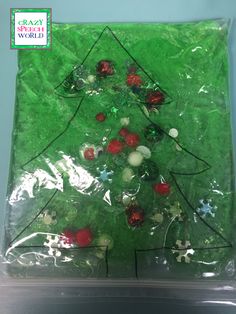 a plastic bag filled with green and red christmas tree decorations on top of a table