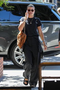 a woman walking down the street while talking on her cell phone