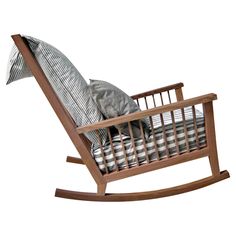 a wooden rocking chair with pillows on it