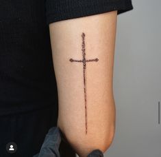 a person with a cross tattoo on their arm