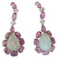 A very gorgeous and beautiful, Opal & Pink Sapphires Chandelier Earrings set in 18K White Gold & natural Diamonds. The weight of the Ethiopian Opals is 6.12 carats. The weight of the Pink Sapphires is 7.60 carats. The Pink Sapphires are of Ceylon (Sri Lanka) origin. The Diamonds weight is 0.64 carats. Net 18K White Gold weight is 7.20 grams. The Gross weight of the Earrings is 10.06 grams. The dimensions of the Earrings are 4.30cm x 1.60cm x 1.00cm (L x W x D). The Earrings have a push back. Fea Luxury Pink Opal Round Jewelry, Luxury Pink Halo Setting Earrings, Luxury Ethiopian Opal Teardrop Jewelry, Luxury Multicolor Temple Jewelry Earrings, Diamond Chandelier Earrings, Diamond Chandelier, Ceylon Sri Lanka, Ethiopian Opal Ring, Blue Sapphire Diamond