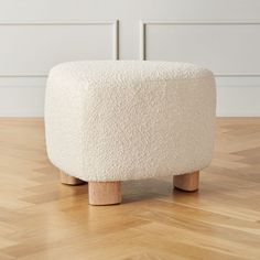 a white stool sitting on top of a hard wood floor