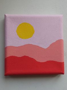 a painting on a white wall with a yellow circle in the center and pink hills below