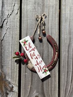 a horseshoe hanging on the side of a wooden fence with a sign that says, be merry