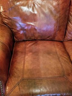 a brown leather chair sitting on top of a hard wood floor