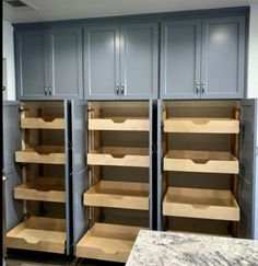 empty shelves in a kitchen with blue cabinets and marble counter tops on the side wall