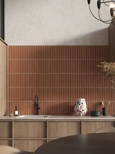 a kitchen with brown tiles on the wall