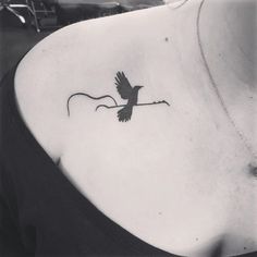 a black and white photo of a bird on the back of a woman's neck