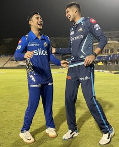 two men standing next to each other on a field