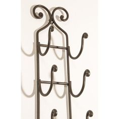 a metal wine rack with three bottles on it's sides and two hooks attached to the wall