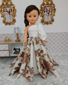 the doll is wearing a white and gold dress