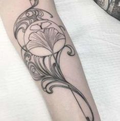 a black and white flower tattoo on the left forearm, with an intricate design in the middle