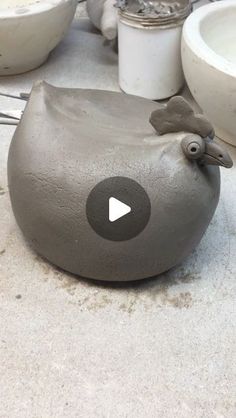 a gray bird shaped object sitting on top of a table next to bowls and utensils