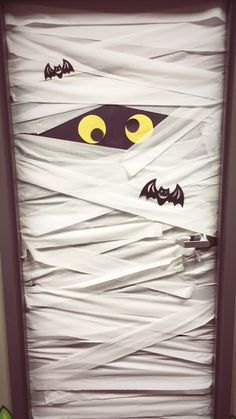 a door decorated with white paper and yellow eyes