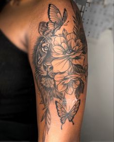 a woman's arm with a tiger and flowers tattoo on the left side of her arm