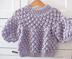 a purple sweater hanging on a white door