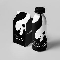 two milk bottles next to each other on a gray background with black and white designs