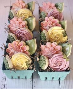 several small trays filled with fake flowers on top of a table