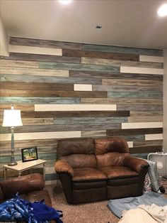 a living room with two couches and a wall made out of wood planks