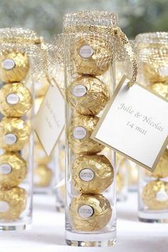 a table topped with vases filled with chocolate covered candies and gold foil wrapped in twine