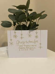 there is a card with a plant in it on top of a table and the name of the wedding date