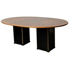 an oval conference table with two black pedestals on each side and a wooden top