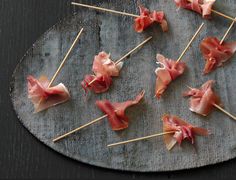 small appetizers with toothpicks are arranged on a metal platter, ready to be eaten