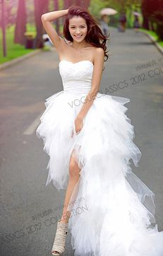 a woman in a white dress is walking down the street