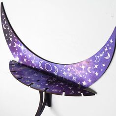 a purple and white crescent shaped shelf with stars on it