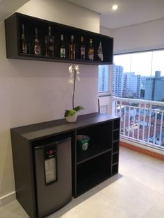 an empty room with shelves and a plant on the counter in front of a window