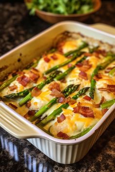 a casserole dish with asparagus, bacon and cheese in it on a counter