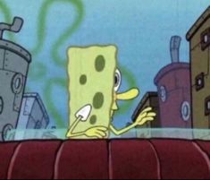 the spongebob is looking at his cell phone while standing on top of a building