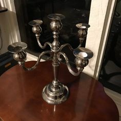 a silver candelabra sitting on top of a wooden table