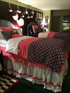 a bed room with two beds covered in red and white blankets next to a window