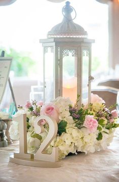 a table with a lantern and flowers on it