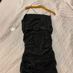 a black dress hanging on a wooden hanger