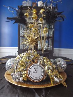 a clock sitting on top of a table covered in confetti and black feathers