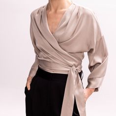 Easy and versatile, this blouse is crafted from high quality viscose fabric and has wide kimono sleeves. It is designed to wrap & tie in different ways. Wrap it around the waist and tie the straps at the front side, for a more classic look. Or cross the straps in the middle front (semi-tie, braided) and then wrap them around the waist and tie them either on the back or the front.  Pair it with its coordinating bias-cut skirt from the collection.   All pieces are cut one by one for an impeccable fit. They are hand-tailored by local Greek artisans in our atelier in Athens, where we design & produce everything, minimising our carbon footprint. We follow a zero-stock policy, minimising waste. We do Slow Fashion. 60% Viscose 40% Rayon Dry Clean or cold delicate hand-wash Soft Dramatic Clothing, Soft Classic Skirts Kibbe, Cross Blouse Designs, Wrap Blouse Outfit, Wrap Around Shirt, Wrap Skirt Outfit, Formal Wrap, Satin Wrap Top, Large Roses