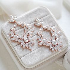 These large cluster style hoop statement earrings catch the light in a truly romantic and glamorous way! Perfect for brides who really want to shine on their special day!- Handcrafted with Premium cubic zirconia stones- All clear stones- Available in rose gold, yellow gold, and rhodium (silver) finishes- Earrings measu Crystal Hoop Jewelry For Weddings, Glamorous Cluster Earrings With Sparkling Stones For Anniversary, Rose Gold Halo Bridal Earrings For Wedding, Dazzling Halo Design Bridal Earrings For Party, Glamorous Round Bridal Earrings With Sparkling Stones, Rose Gold Bridal Earrings With Sparkling Cubic Zirconia, Glamorous Cubic Zirconia Hoop Earrings For Wedding, Wedding Bridal Earrings In Rose Gold With Halo Design, Glamorous Rose Gold Cubic Zirconia Chandelier Earrings