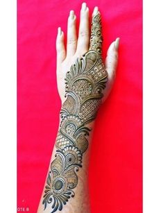 a woman's hand with henna tattoos on it