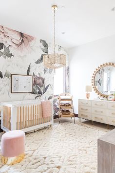 a baby's room with floral wallpaper and furniture